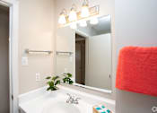 Thumbnail 5 of 9 - A bathroom with a white sink and a mirror above it.