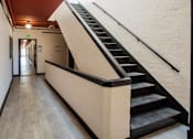 Thumbnail 9 of 13 - A hallway with a staircase on the right side.