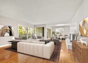 Thumbnail 10 of 27 - A modern living room with a white sofa and a wooden floor.