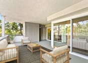 Thumbnail 15 of 27 - A modern living room with a glass door leading to a balcony.