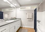 Thumbnail 14 of 27 - A bathroom with a sink, mirror, and shower.