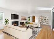 Thumbnail 9 of 27 - A modern living room with a fireplace and a flat screen TV.
