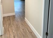 Thumbnail 11 of 18 - a hallway wiPeachgrove Apartments Hallwayth a wooden floor and a window