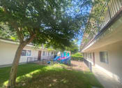 Thumbnail 2 of 7 - a playground in a yard next to a building