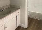 Thumbnail 11 of 21 - A white bathroom with a sink and mirror.