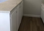 Thumbnail 7 of 21 - A kitchen with white cabinets and a counter top.