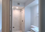 Thumbnail 11 of 22 - Punahou Circle bathroom with a toilet, sink, and walk-in shower.