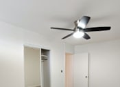 Thumbnail 8 of 22 - Punahou Circle bedroom with a ceiling fan and a door with a mirror on the wall.