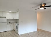 Thumbnail 1 of 22 - Punahou Circle kitchen with white appliances and wooden floors.
