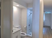 Thumbnail 20 of 22 - A bathroom with a toilet, sink, and shower.