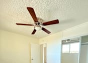 Thumbnail 8 of 18 - A room with a ceiling fan and wooden flooring.