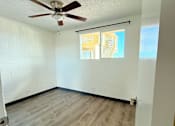 Thumbnail 9 of 18 - A room with a ceiling fan and a window with blinds.