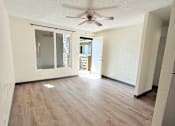 Thumbnail 1 of 18 - A room with a ceiling fan and wooden flooring.