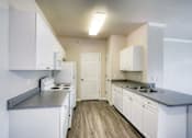 Thumbnail 20 of 20 - A kitchen with white cabinets and a white stove top oven.