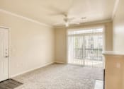 Thumbnail 18 of 20 - A room with a carpeted floor, a ceiling fan, and a sliding glass door.