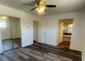 Thumbnail 6 of 16 - Seaview bedroom with a ceiling fan and wooden flooring.