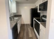 Thumbnail 5 of 16 - Seaview kitchen with black appliances and white cabinets.