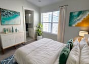 Thumbnail 8 of 32 - A bedroom with a large bed and a painting on the wall.