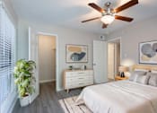 Thumbnail 3 of 47 - A bedroom with a bed, dresser, and ceiling fan.