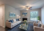 Thumbnail 2 of 47 - A living room with a white couch, a coffee table, and a ceiling fan.