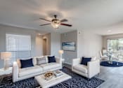 Thumbnail 1 of 47 - A living room with a white couch and a ceiling fan.