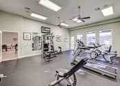 Thumbnail 13 of 19 - A spacious gym with treadmills, elliptical machines, and a weight machine.