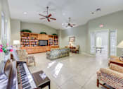 Thumbnail 15 of 19 - A living room with a piano and a bookcase.