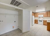 Thumbnail 9 of 19 - A kitchen with white appliances and wooden cabinets.