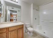Thumbnail 6 of 19 - A white bathroom with a toilet, sink, and bathtub.