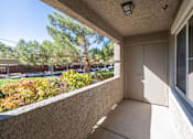 Thumbnail 1 of 19 - A balcony with a door and a window overlooking a parking lot.