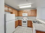 Thumbnail 4 of 19 - A kitchen with white appliances and wooden cabinets.