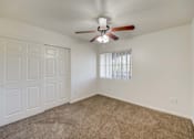 Thumbnail 8 of 19 - A room with a ceiling fan and a window with blinds.