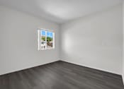 Thumbnail 31 of 48 - A room with a window and wooden flooring.