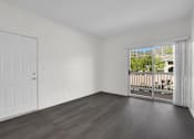 Thumbnail 15 of 48 - A room with a white door and a window with a view of a balcony.