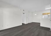 Thumbnail 18 of 48 - A large empty room with wooden floors and white walls.