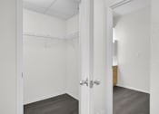 Thumbnail 32 of 48 - A white door with a silver handle is open to a hallway.