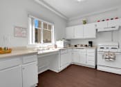 Thumbnail 8 of 48 - A kitchen with white cabinets and a stove top oven.