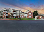 Thumbnail 6 of 33 - A row of apartment buildings with a car parked in front.