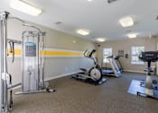 Thumbnail 13 of 33 - A gym with a variety of equipment including a treadmill, a stationary bike, and a weight machine.