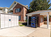 Thumbnail 12 of 33 - A white garage door is on the left and a brick building with a sign that says Cold Drinks is on the right.