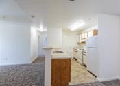 Thumbnail 31 of 33 - A kitchen with white appliances and wooden cabinets.