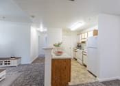 Thumbnail 17 of 33 - A kitchen with white appliances and wooden cabinets.