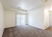 Thumbnail 26 of 33 - A room with a carpeted floor and a window with blinds.