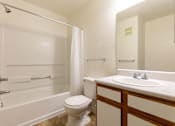 Thumbnail 32 of 33 - A white bathroom with a toilet, sink, and bathtub.