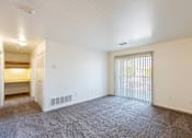 Thumbnail 25 of 33 - A spacious room with carpeted floor and a sliding glass door.