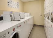 Thumbnail 6 of 15 - a washer and dryer room in a building with washing machines