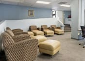 Thumbnail 12 of 15 - a waiting room with a row of chairs and a table