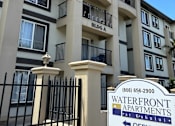 Thumbnail 23 of 24 - A sign for Waterfront Apartments is in front of a building.