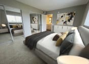 Thumbnail 9 of 39 - a bedroom with a large bed and a large mirror