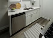 Thumbnail 5 of 39 - a small kitchen with white cabinets and a sink